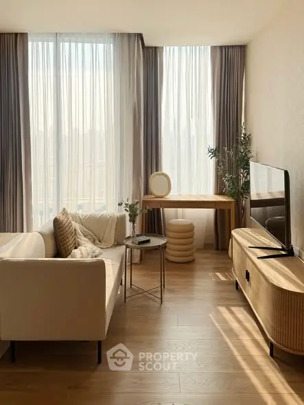 Elegant living room with modern furniture and large windows offering natural light.