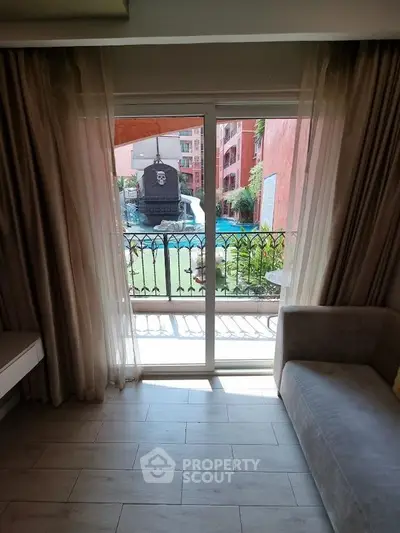 Charming living room with pool view through elegant curtains and sliding glass doors.