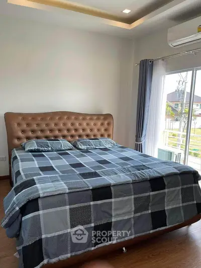 Spacious bedroom with elegant bed and large window offering natural light