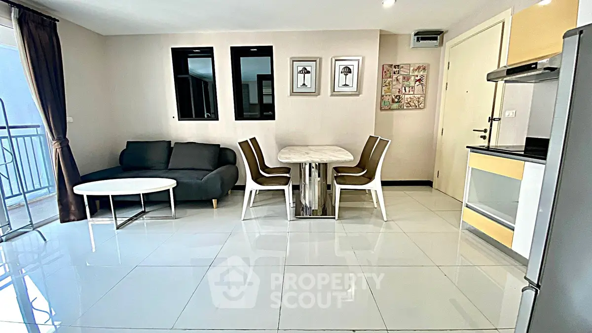 Modern living room with sleek furniture and dining area in open layout apartment.
