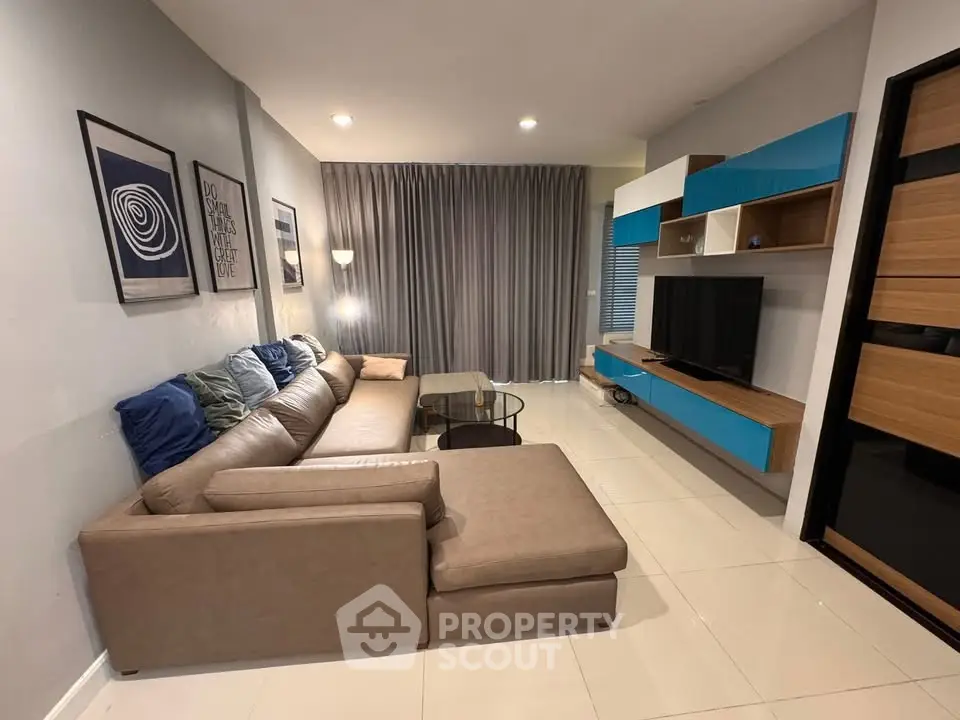 Modern living room with stylish sectional sofa and sleek entertainment unit.