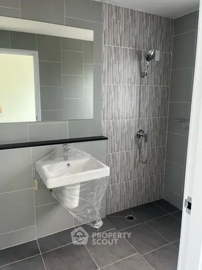 Modern bathroom with sleek tiles and wall-mounted sink