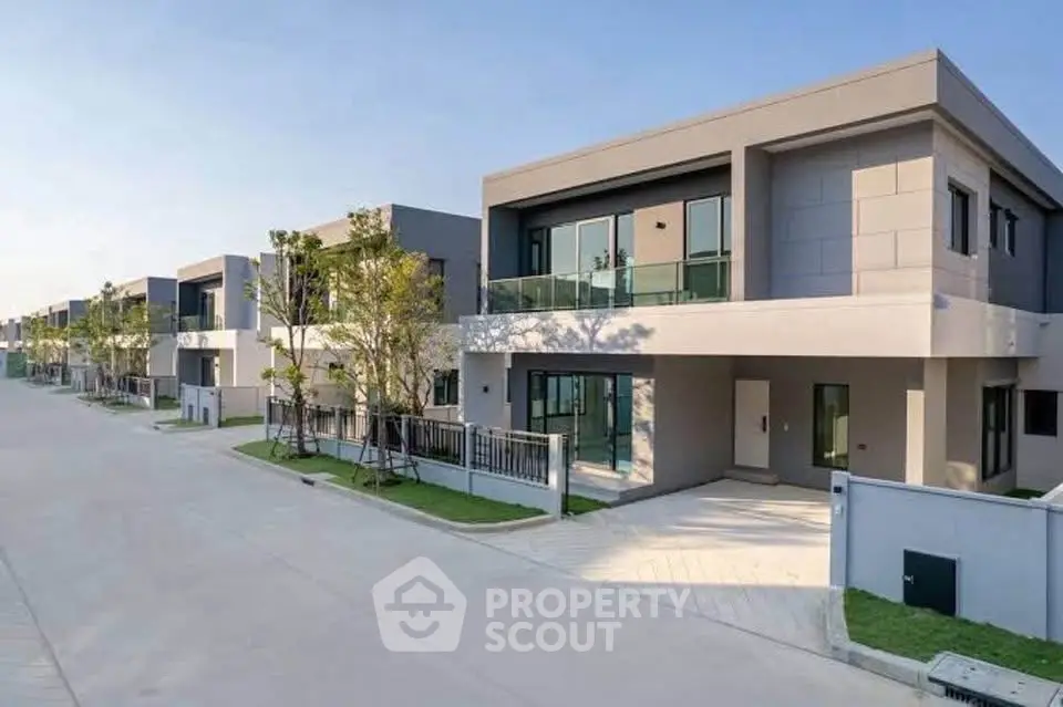 Modern townhouse exterior with sleek design and spacious driveway in a serene neighborhood.