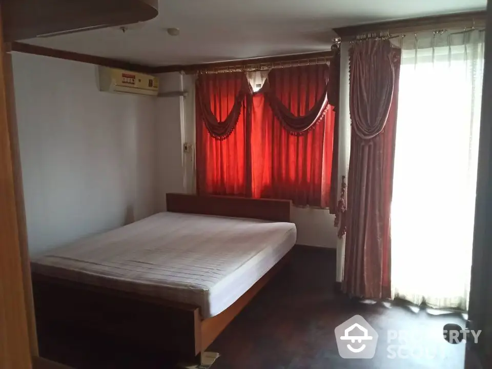 Cozy bedroom with red curtains and natural light