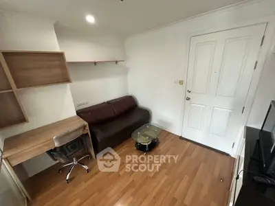 Cozy living room with wooden flooring, leather sofa, and modern glass coffee table.