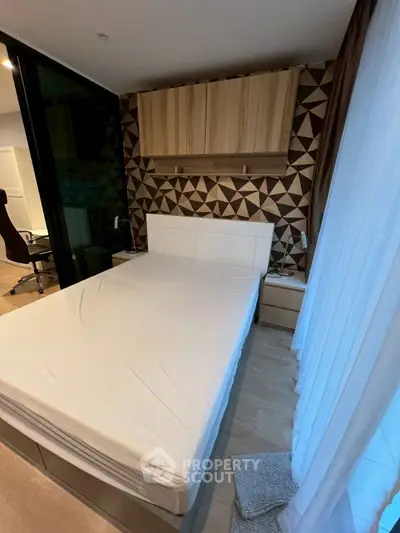 Modern bedroom with stylish geometric accent wall and natural light