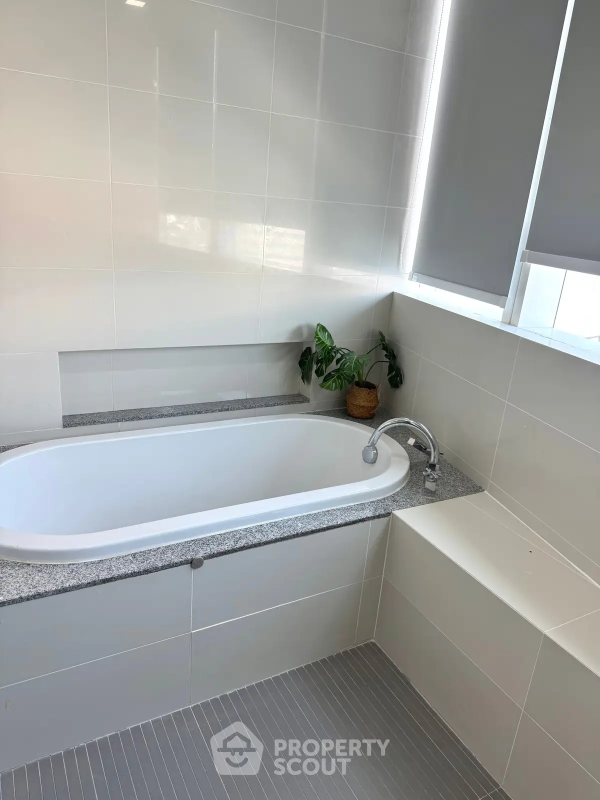 Modern bathroom with sleek bathtub and stylish tile design, perfect for relaxation and comfort.