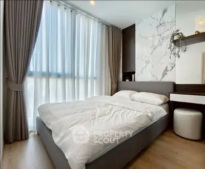 Luxurious bedroom with elegant decor and floor-to-ceiling windows in modern apartment.