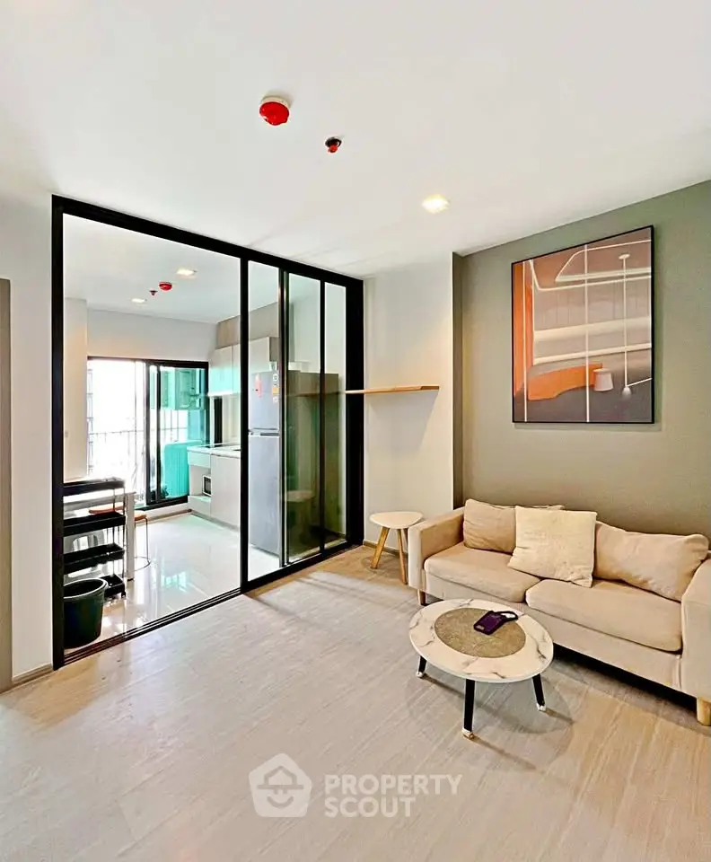 Modern living room with glass partition and stylish decor in a contemporary apartment.