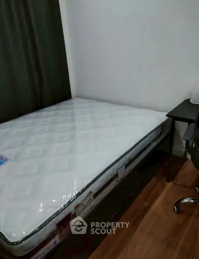 Cozy bedroom with a new mattress and study desk, perfect for students or professionals.