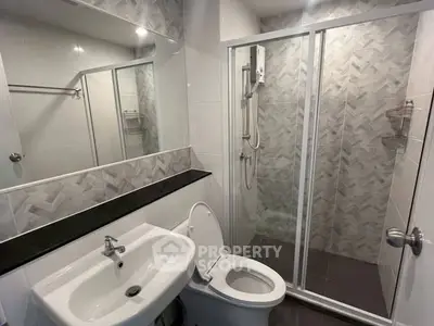 Modern bathroom with sleek fixtures and glass shower enclosure.