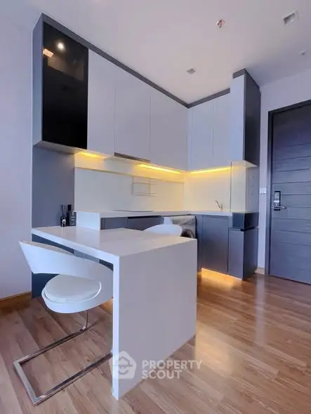 Modern kitchen with sleek cabinetry and integrated appliances in a stylish apartment.