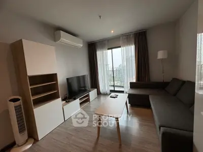 Modern living room with sleek furniture and large window offering city views.