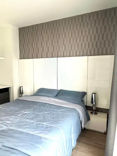 Modern bedroom with stylish decor and cozy bedding in a contemporary apartment.
