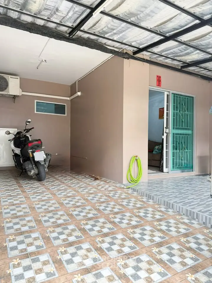 Spacious covered parking area with tiled flooring and motorbike, ideal for urban living.