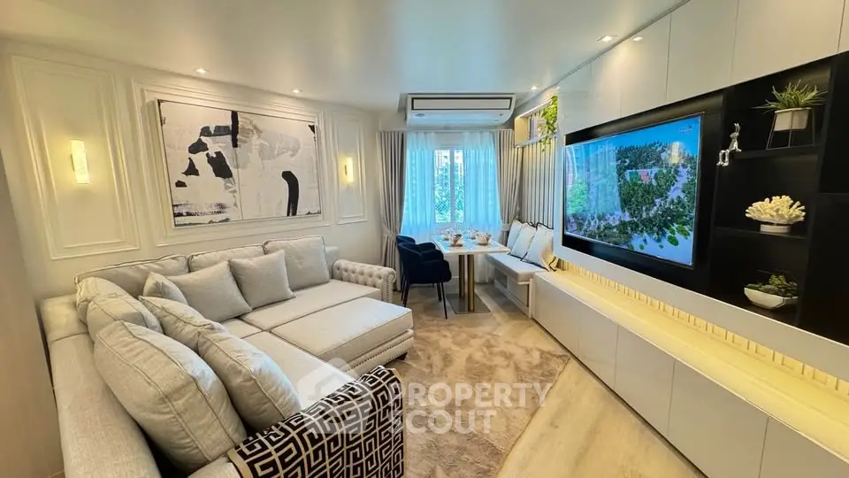 Luxurious living room with modern decor, plush seating, and large TV, perfect for relaxation and entertainment.