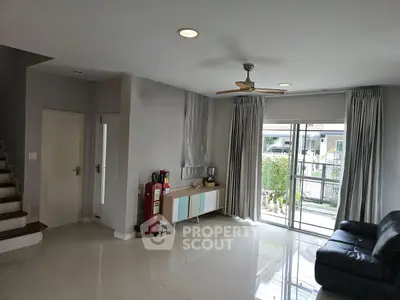 Spacious modern living room with sleek flooring and large windows for natural light.