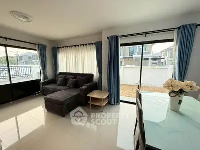 Modern living room with large windows and stylish furniture in a bright, spacious setting.