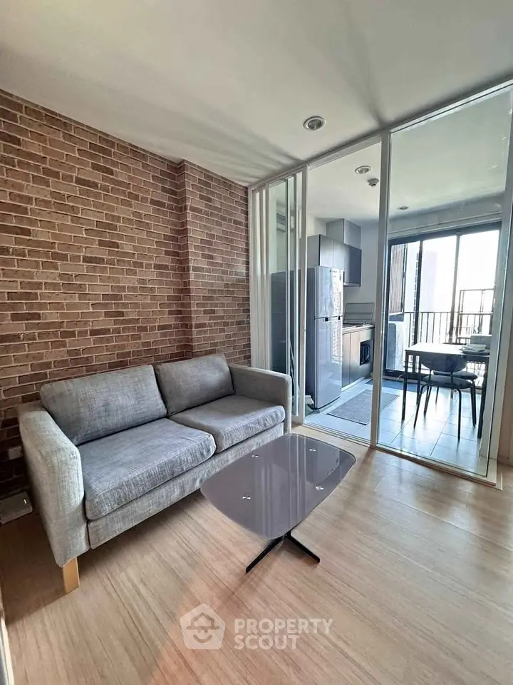 Modern living room with brick accent wall and open kitchen layout in stylish apartment