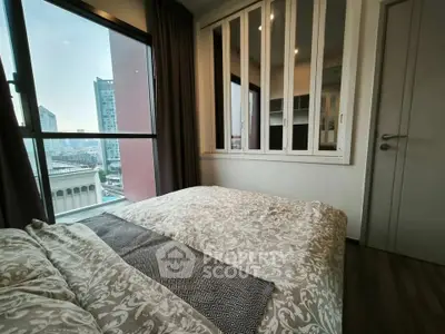 Cozy bedroom with city view, featuring large windows and elegant decor in a modern apartment.