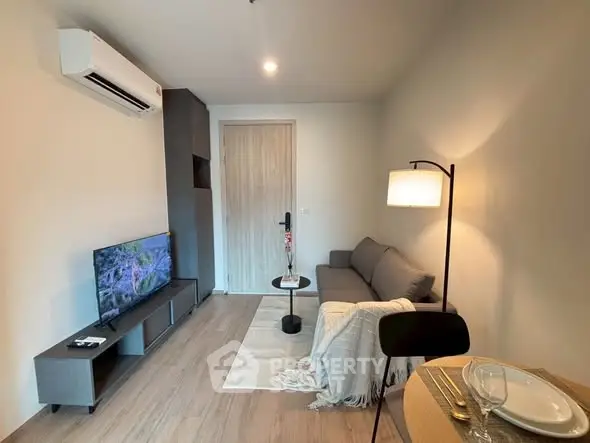 Modern living room with cozy sofa, TV, and elegant lighting in a stylish apartment.