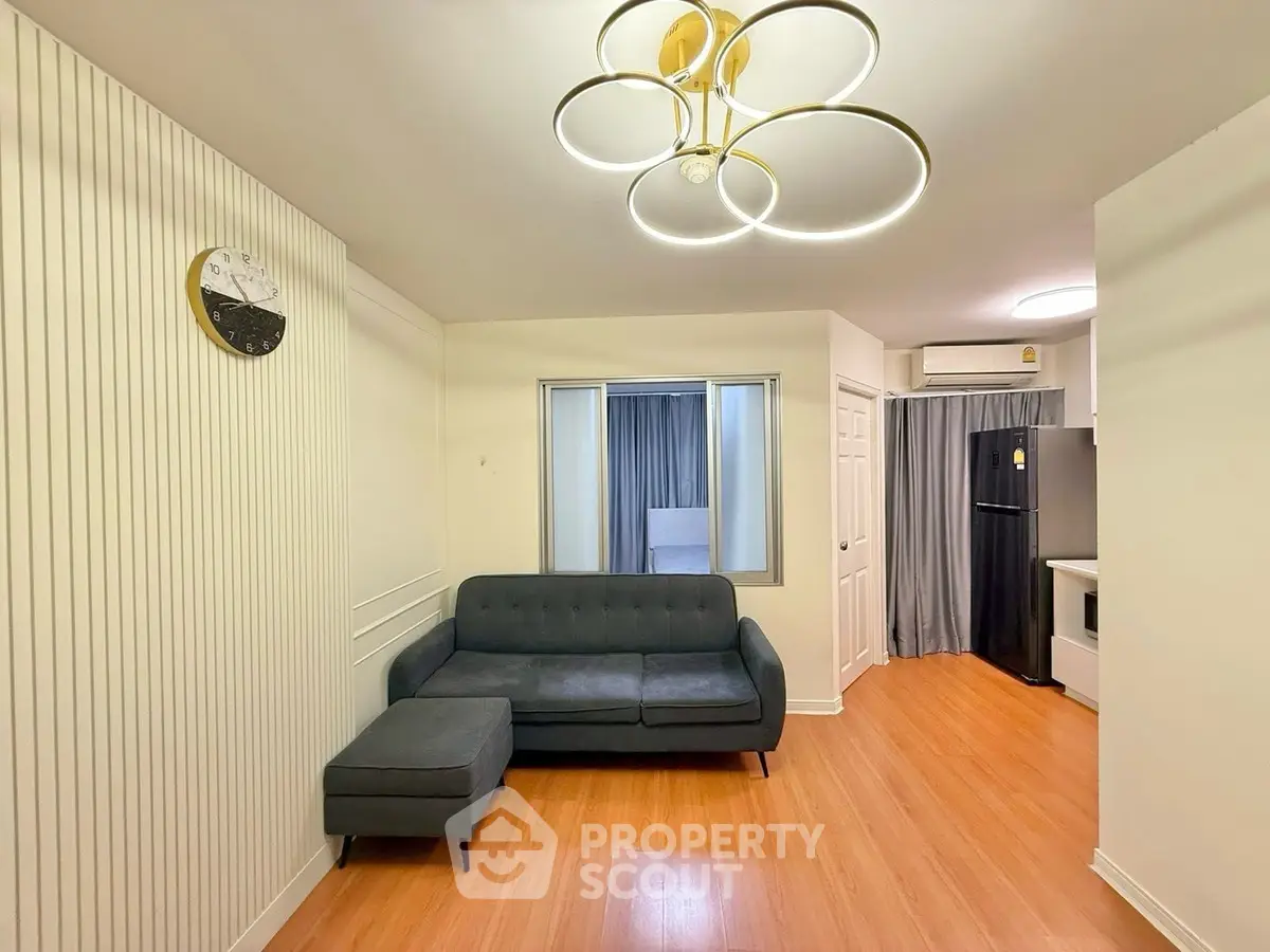 Modern living room with stylish lighting and cozy sofa in open layout apartment.