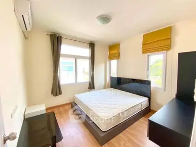 Bright and airy bedroom with large windows and modern furnishings.