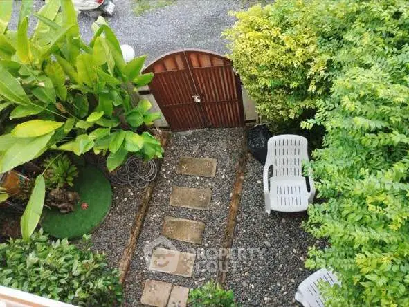 Charming garden entrance with lush greenery and stone pathway