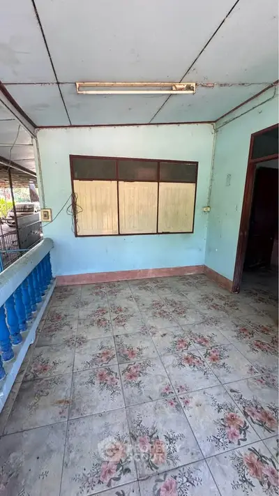 Charming vintage porch with floral tile flooring and rustic blue railing, perfect for relaxation.