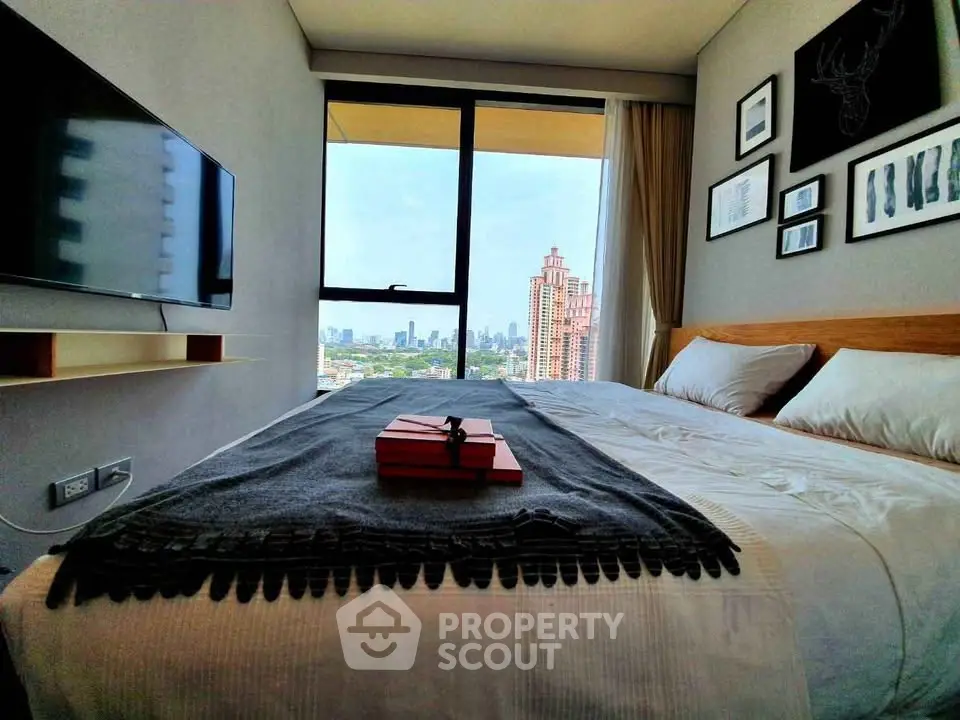 Modern bedroom with city view, wall-mounted TV, and stylish decor