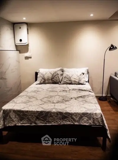 Cozy bedroom with elegant bedding and modern lighting, perfect for relaxation.