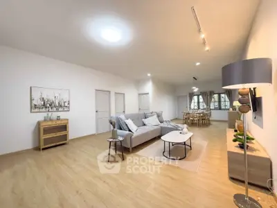 Spacious modern living room with stylish decor and open dining area.