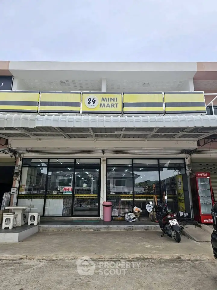 Street view of a modern mini mart with glass facade and parking area, ideal for retail business.