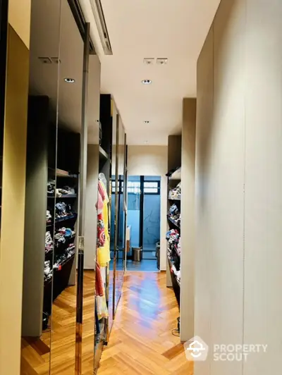 Luxurious walk-in closet with elegant wooden flooring and ample storage space.