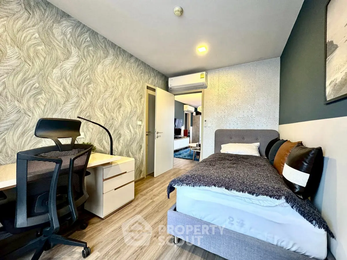 Modern bedroom with stylish decor and workspace in a cozy apartment.