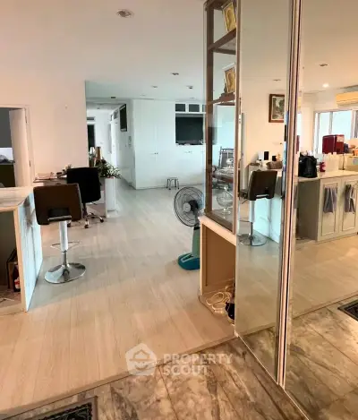 Spacious open-plan living area with modern decor and mirrored accents