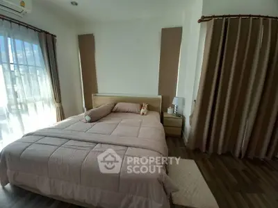 Cozy bedroom with soft lighting and elegant curtains, featuring a comfortable bed and stylish decor.