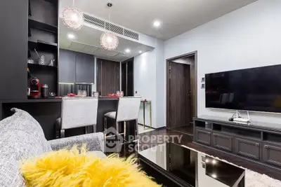 Modern living room with open kitchen, stylish decor, and cozy seating area.
