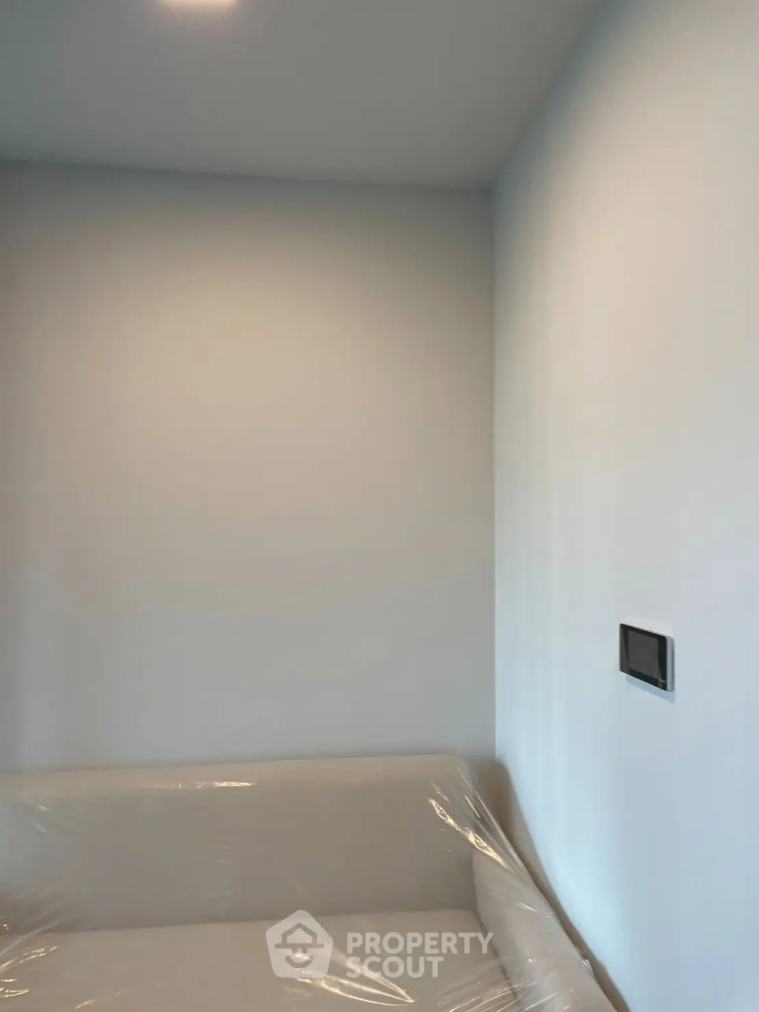 Minimalist interior with white walls and a wrapped sofa, perfect for modern living.