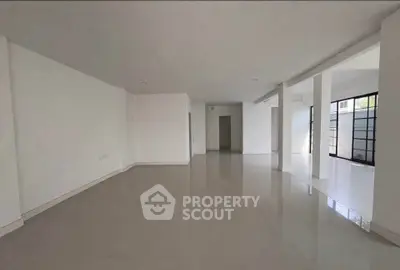 Spacious open-plan living area with sleek tiled flooring and ample natural light.