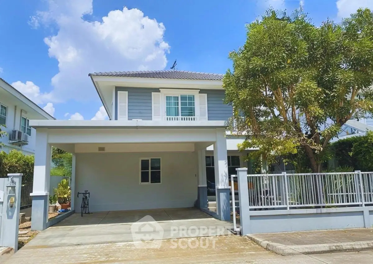 Charming two-story house with spacious driveway and lush greenery, perfect for family living.