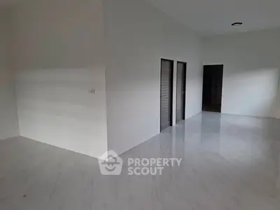 Spacious empty room with sleek marble flooring and modern doors
