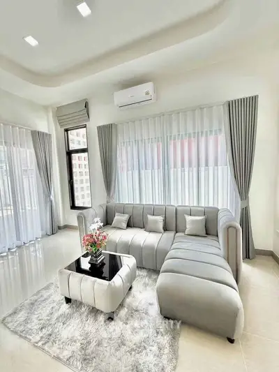 Elegant living room with modern gray sofa and large windows, perfect for natural light lovers.