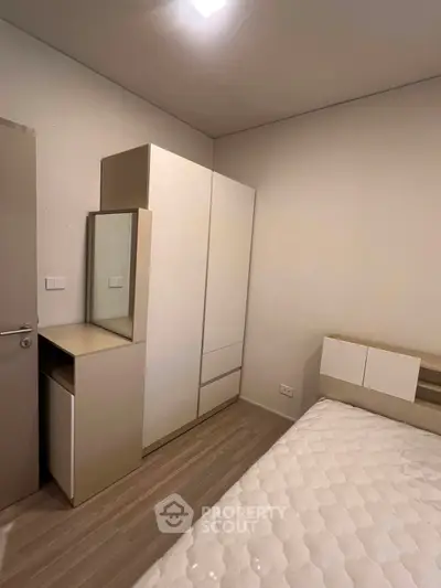 Modern bedroom with sleek wardrobe and comfortable bed in minimalist design.