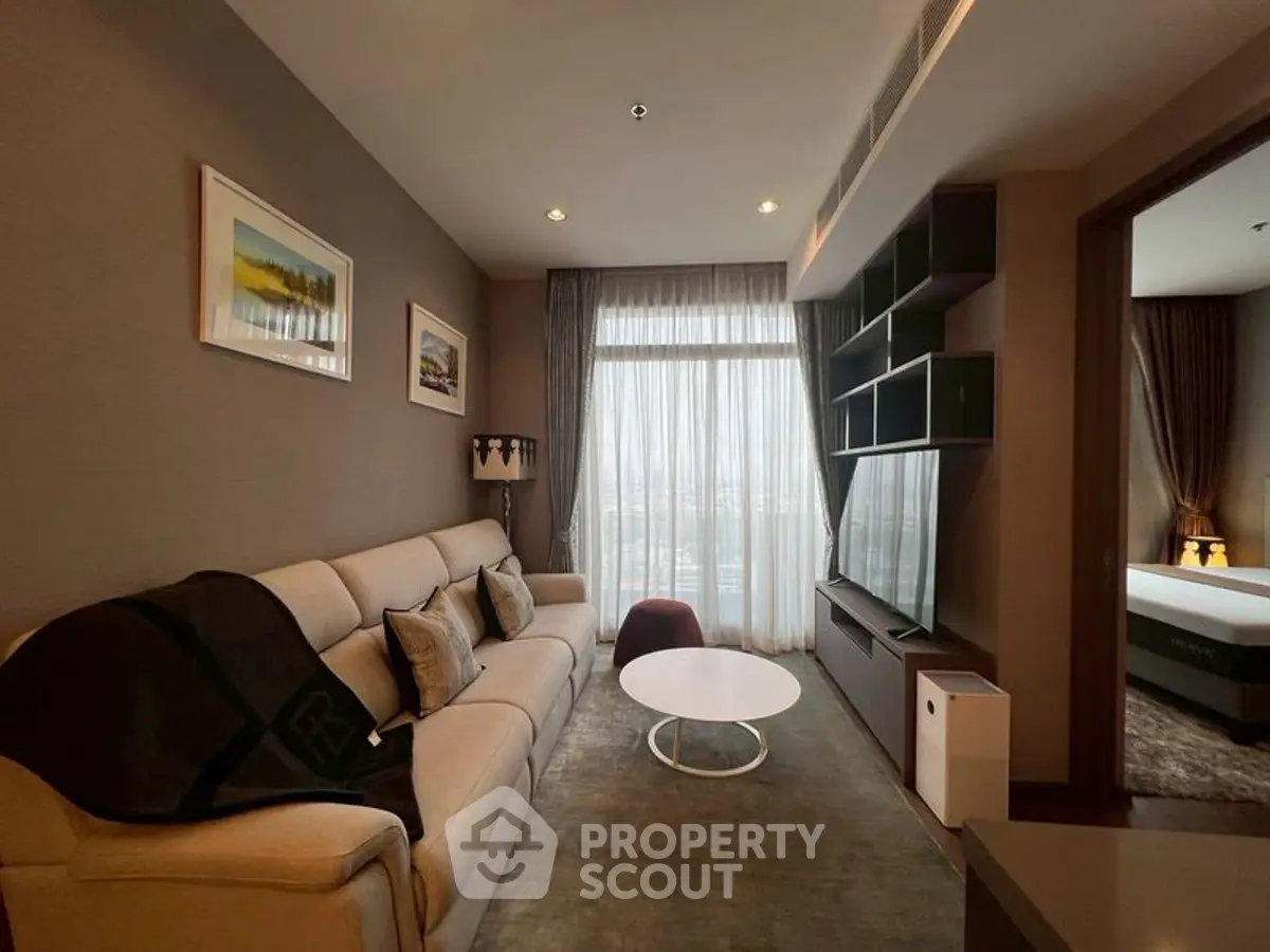 Modern living room with cozy sofa and large TV, adjacent to a stylish bedroom.