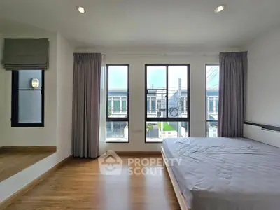 Spacious bedroom with large windows offering natural light and modern design.