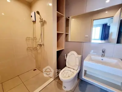 Modern bathroom with sleek fixtures and spacious shower area in a contemporary apartment.