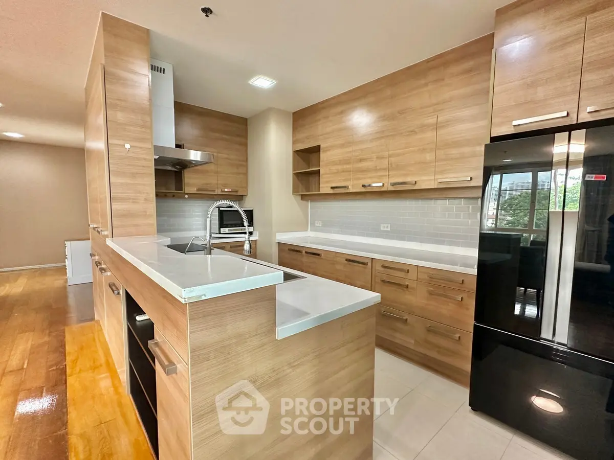 Modern kitchen with sleek wooden cabinets and black appliances