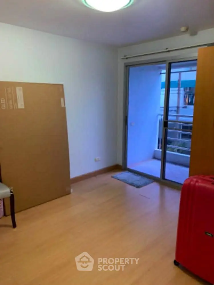 Spacious room with balcony access and wooden flooring, ideal for customization.