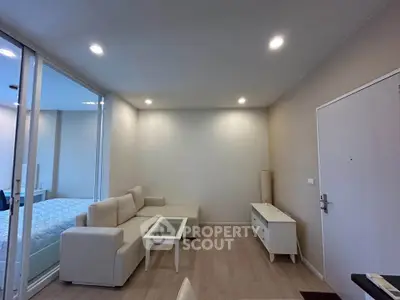 Modern living room with beige sofa and glass coffee table in a cozy apartment